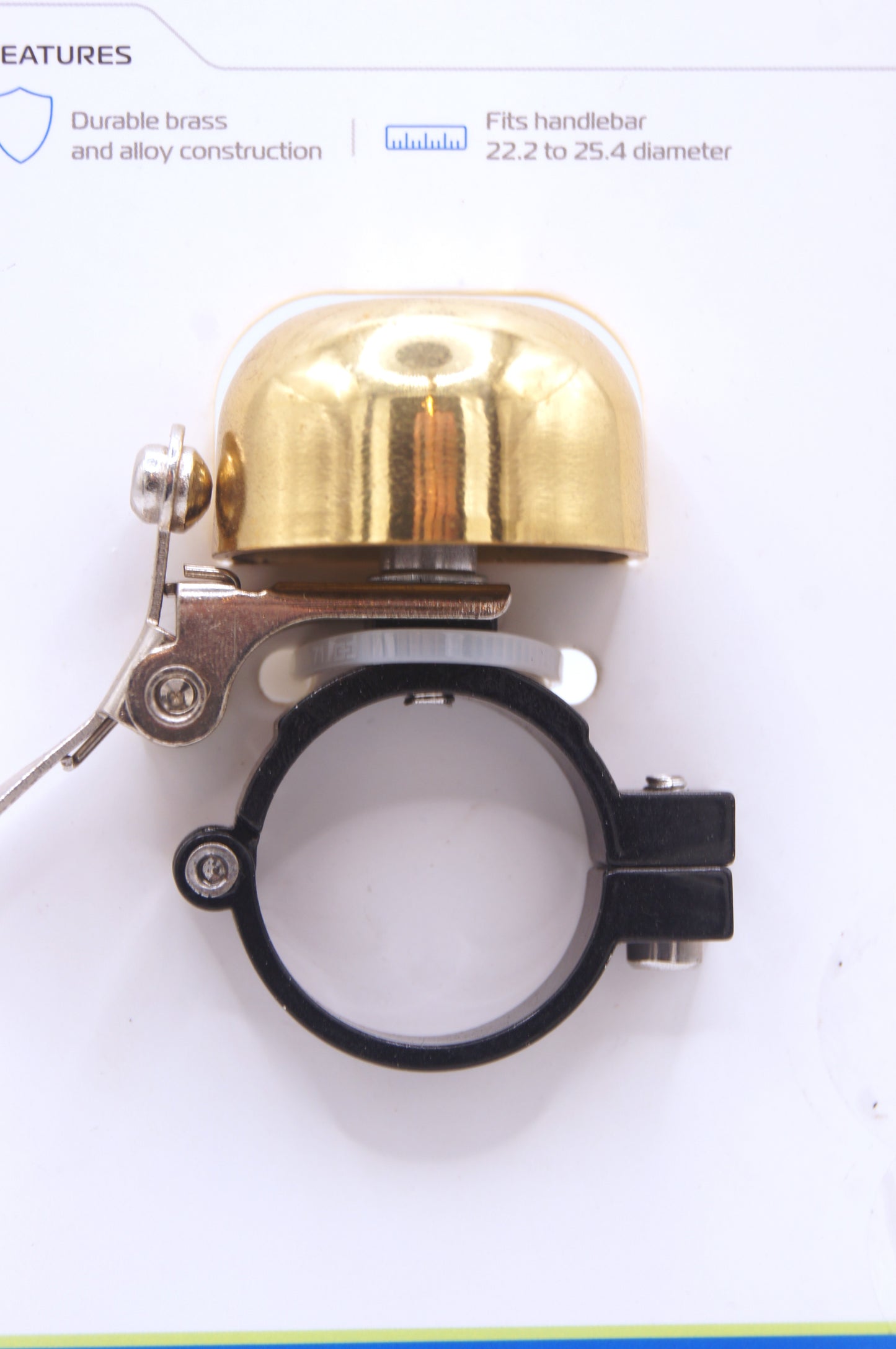 Gold bicycle bell with black mounting clamp.
