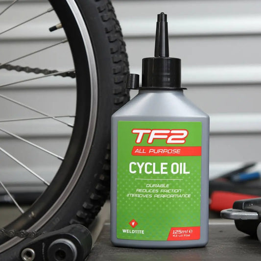 Weldtite TF2 All-Purpose Cycle Oil 125ml being applied to a bike chain